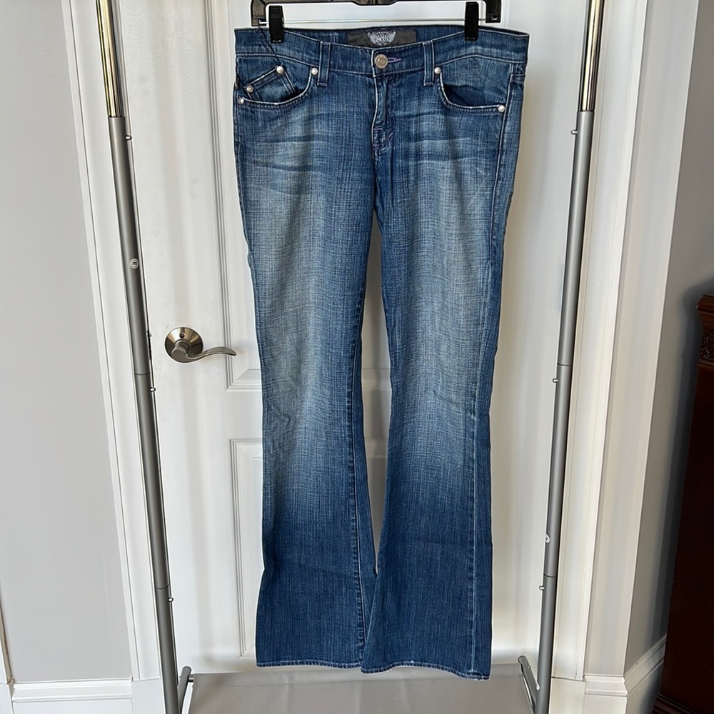 Medium wash flare jeans with purple embellishments